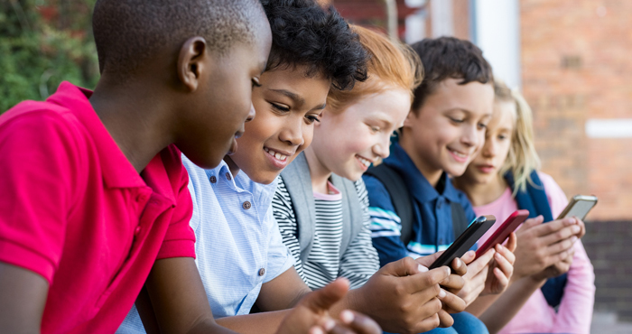 Row of kids on smartphones