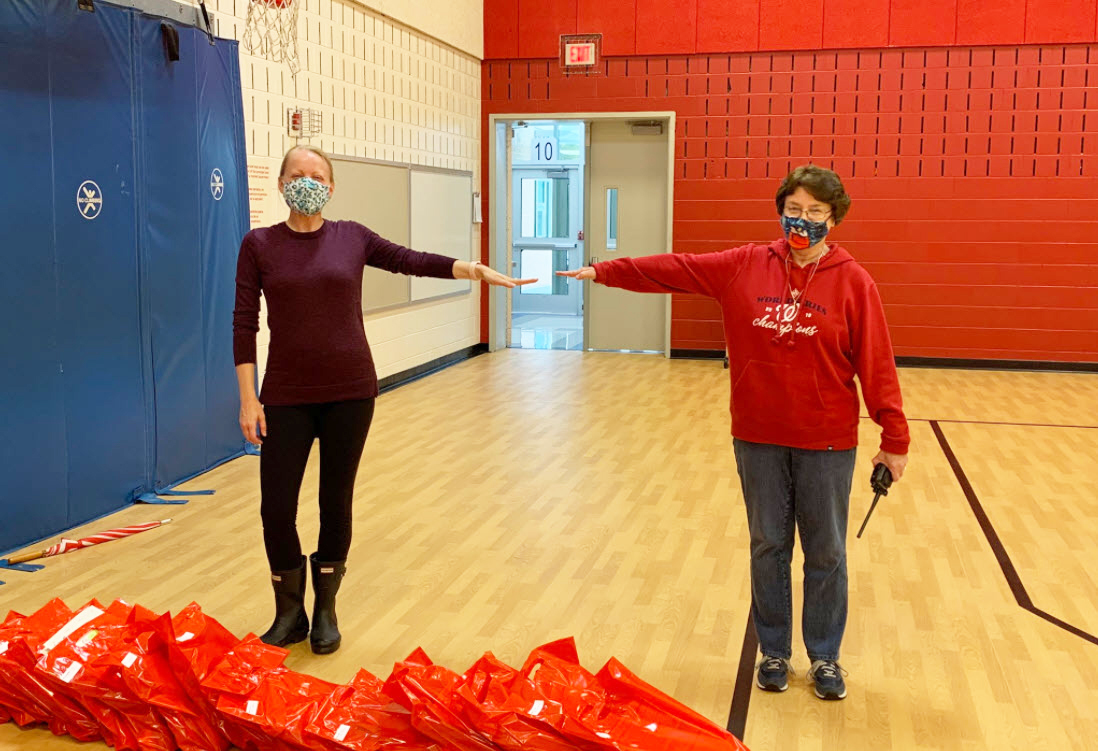 Renee Riddell (left) and Jane Conner (right), teachers at Forestville ES, during supply distribution in school gym.