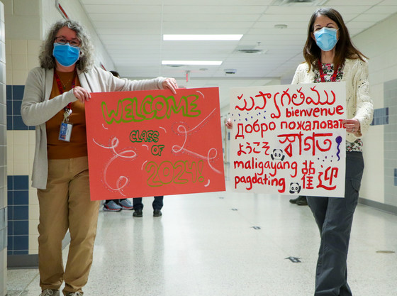 Teachers with Multilanguage welcome signs 