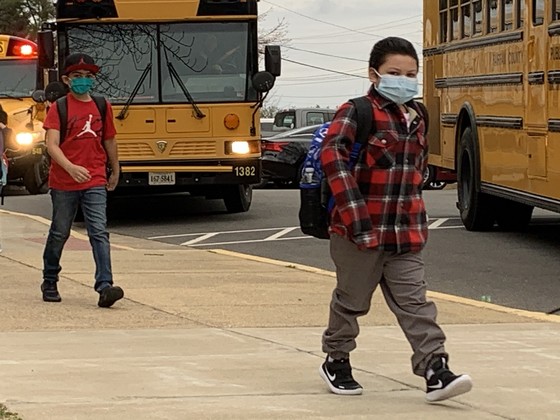 Photo of students walking from bus to school
