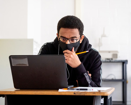 Student in mask working on computer
