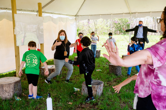 Teacher and students in outdoor learning tent