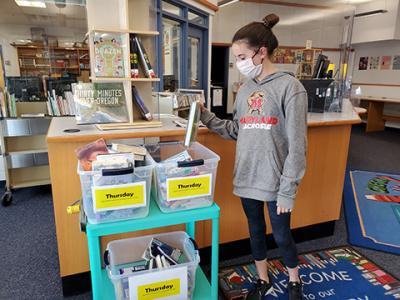 Longfellow MS student returning library book
