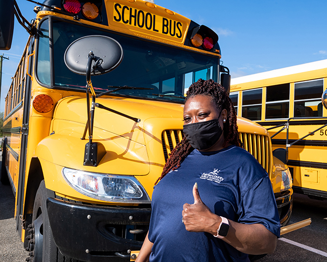 photo of bus driver Bonnie Napper in front of her school bus