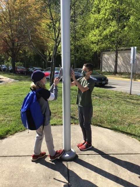 two students raising the flag at school