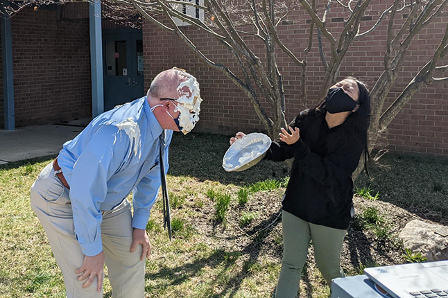 photo of principal Sam Elson getting a pie in the face from a student