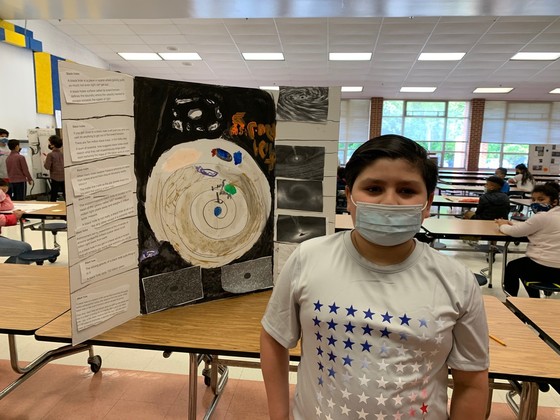Photo of student with his research project