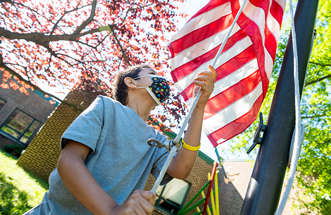 photo of boy raising the flag