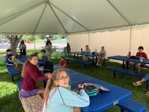 Picture of students eating lunch in tent.
