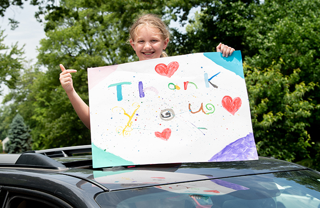 Student with thank you sign