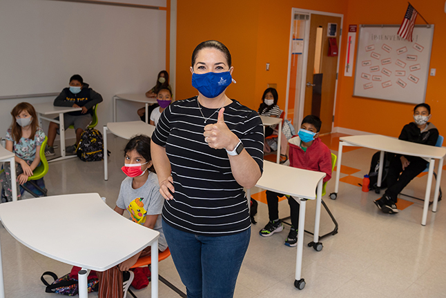 photo of a teacher in a classroom with a mask on
