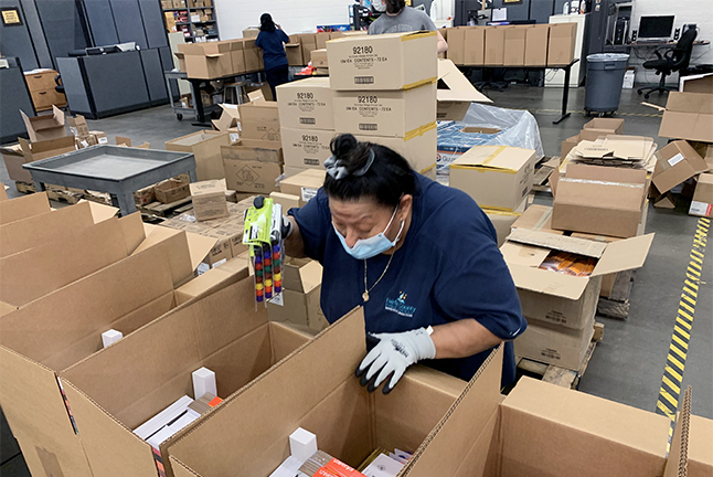 photo of warehouse worker packing summer learning kits