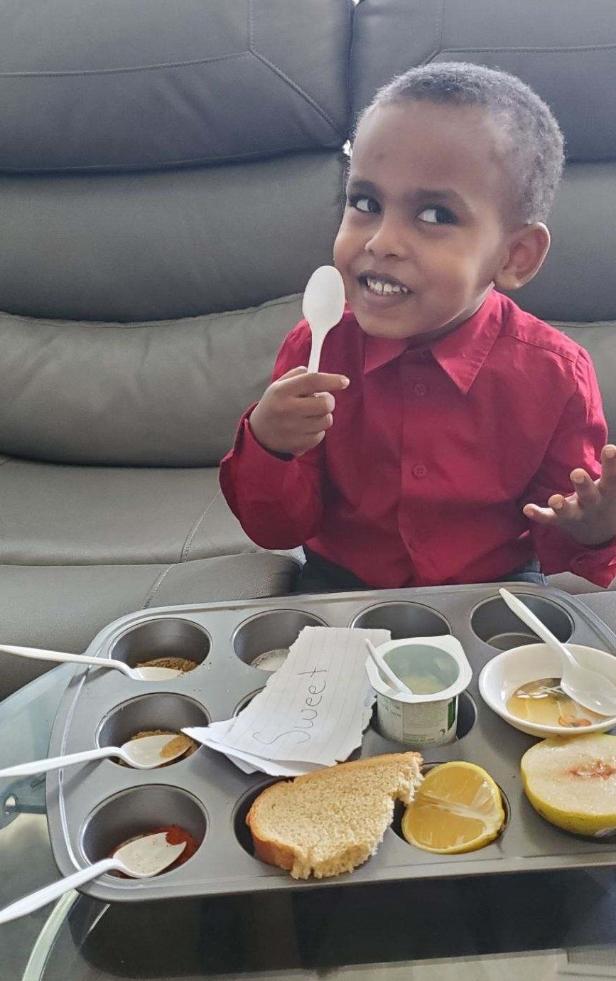 Photo of a child participating in a preschool lesson about taste