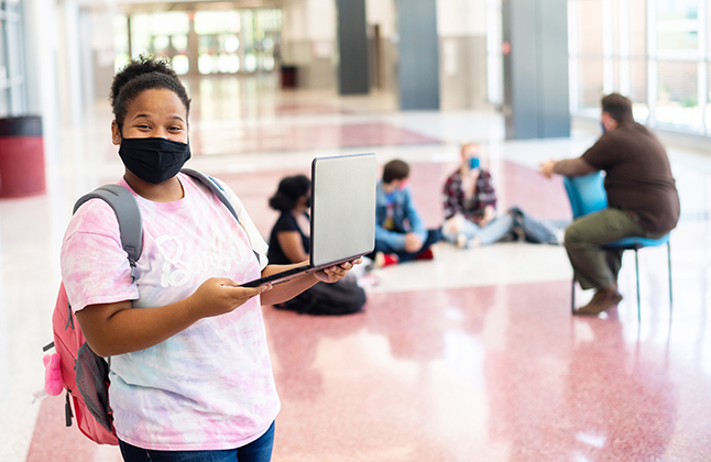 photo of student holding a laptop