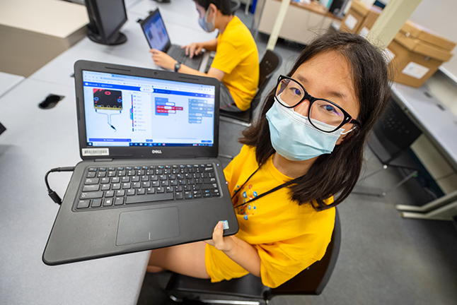 Girl in mask holding a computer