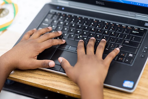 Child's hands typing on a computer