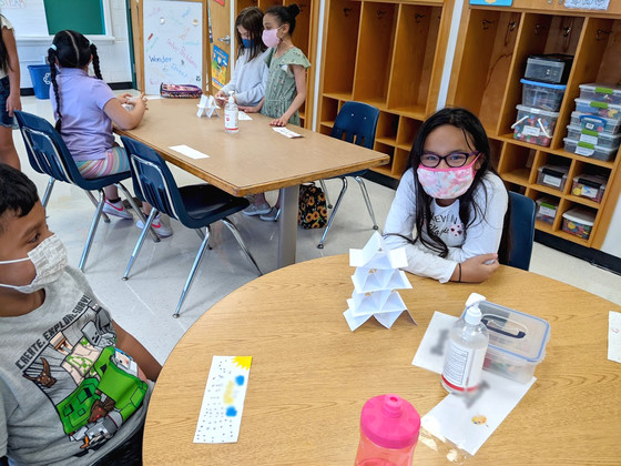 Student smiling at the camera through her mask while in a STEAM lesson