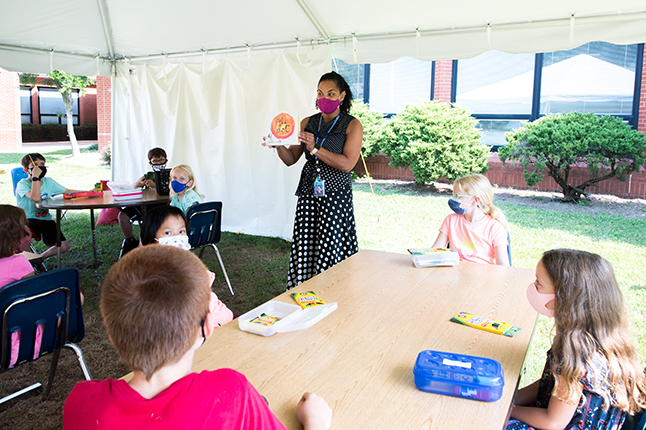 Teacher in front of an outdoor classroom.
