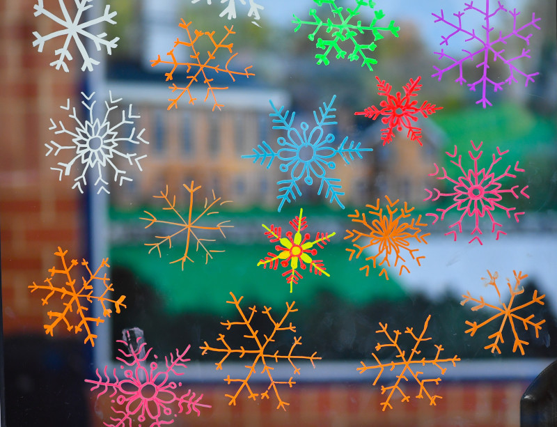 photo of cut out construction paper snowflakes on a window