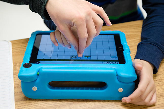 photo of hand pushing buttons on assistive technology device