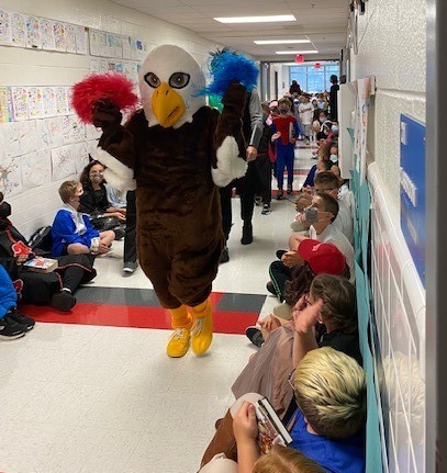 Ernie the Eagle waves pom poms in the Clermont hallway. 