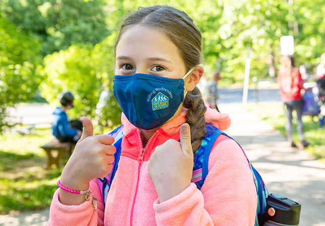 photo of girl with Walking Wednesday mask giving a thumbs up