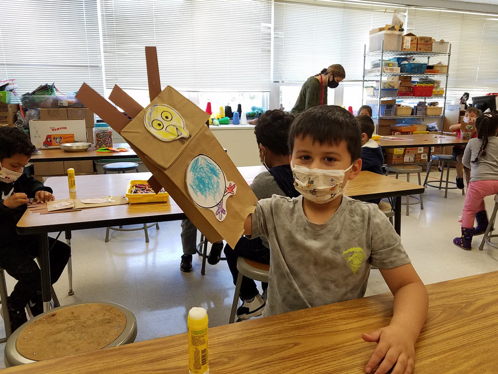 prek student and paper turkey puppet