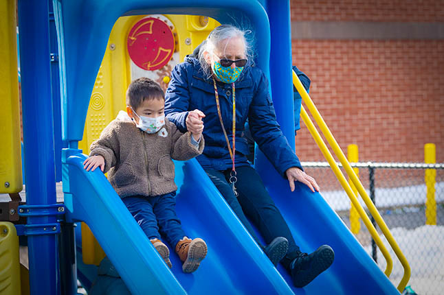 Teacher and student sliding down a slide.