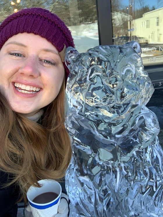 Photo of a woman's face next to an ice sculpture of a woodchuck