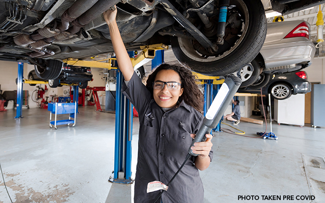 Female student in an automotive repair shop. 