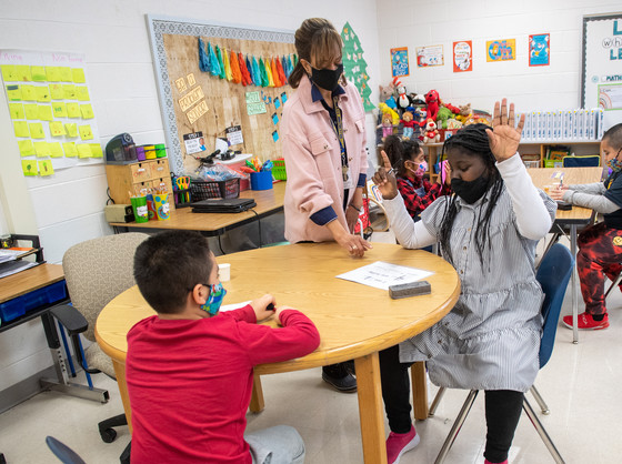Teacher and students at a table.