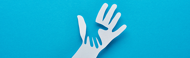Cutout of an adult hand holding a child's hand. 