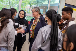 Michelle Reid speaking with a group of students. 