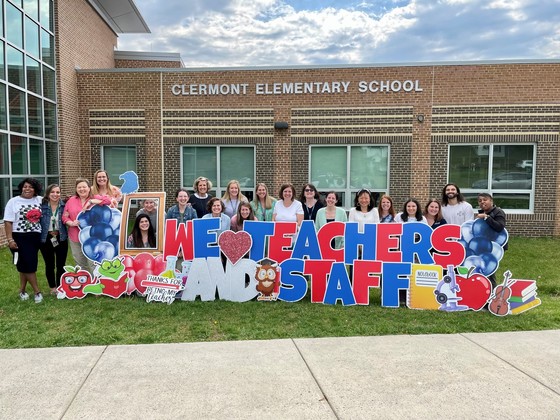 Clermont staff members pose in front of the staff appreciation sign. 