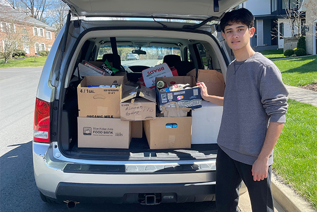 Madison High School sophomore Nirav Ramchandani, founder of Cease Hunger, by a van filled with food to donate to other students.