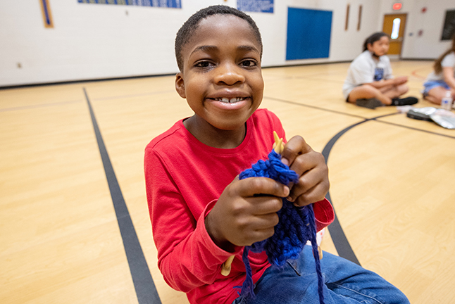 Young student shows off knitting