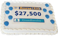 A cake that reads Scores for Kids, $27,500.00 and GrandInvolve