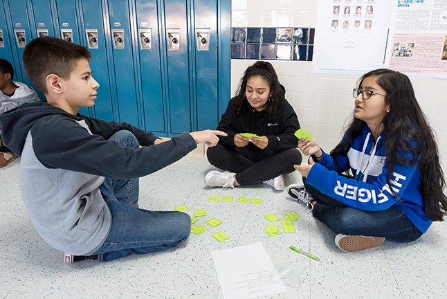 Herndon Middle School Students working together while sitting in a circle on the floor.