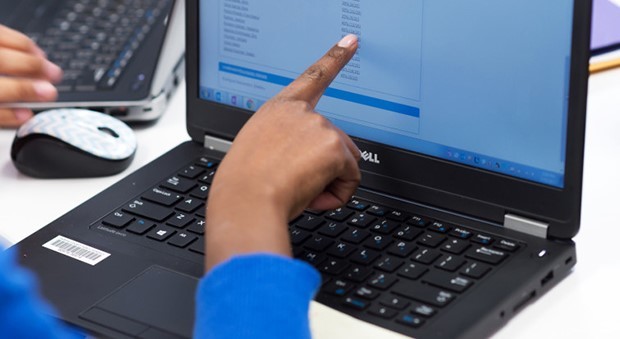 child's hand pointing at a computer screen