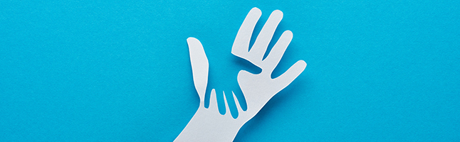 A white paper hand with the shape of a hand cut out of it over a blue background.