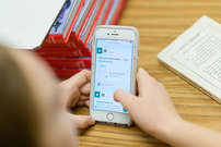 a young person scrolls on a cell phone