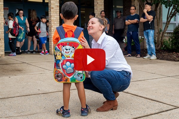 A mother says goodbye to her son on his first day of school. Link to vide. 