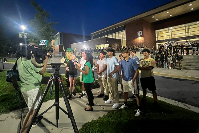 A news team goes live in front of Langley High school on the first day of school 