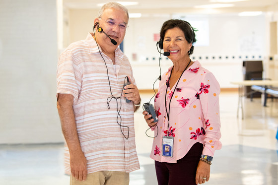 Two interpreters smile while wearing headsets