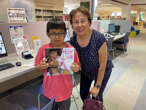 New Ignite Partner Read-On Young Readers volunteer ready to read together the book Hair Love.