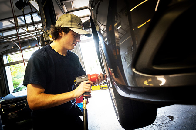 An FCPS student involved in Career and Technical Education (CTE) servicing a vehicle while on a workplace internship. 