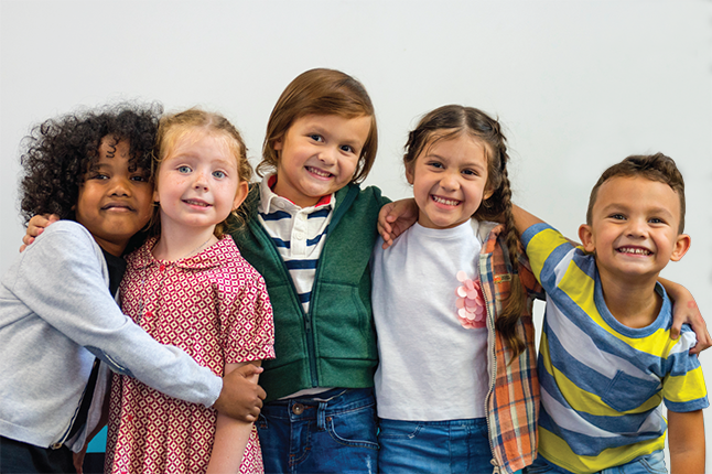 Five smiling elementary students arm-in-arm.