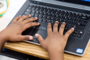 Child's hands on laptop keyboard
