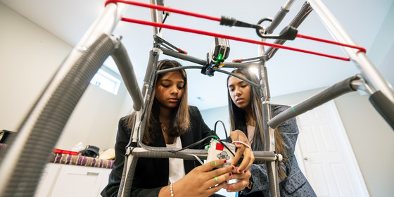 Two students work on altering a walker to help people with Parkinson's disease. 