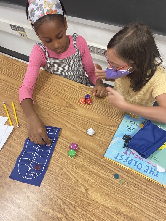 Two girls looking at a set of dice to take data